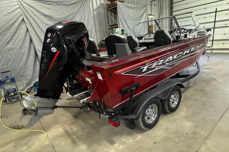 Slide: The Image of 2019 Tracker Targa V-19 Combo boat in a garage, featuring a powerful outboard motor. - 3