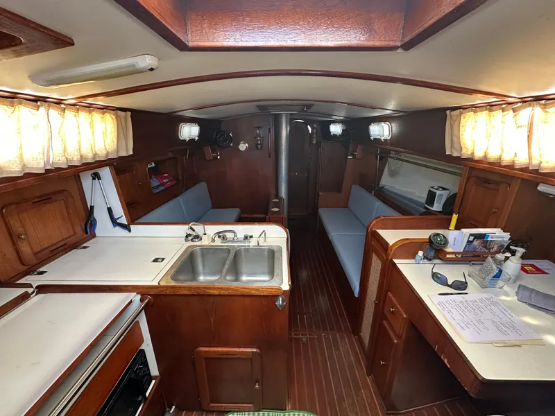 Slide: The Image of Interior of a 1980 Morgan 382 sailboat with wood finish and compact kitchen area. - 1