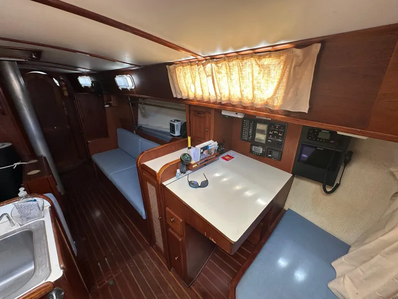 Slide: The Image of 1980 Morgan 382 yacht interior with wooden finish, seating area, and navigation equipment. - 10