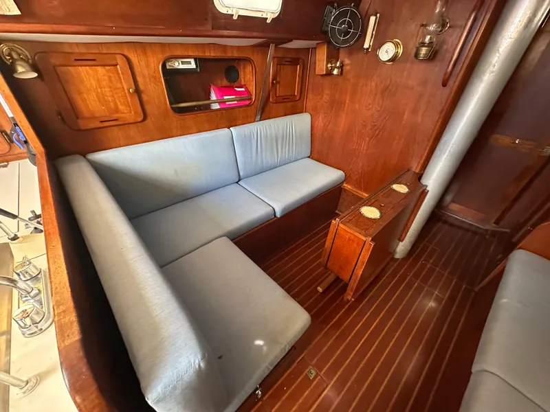 Slide: The Image of 1980 Morgan 382 yacht interior with blue seating, wooden paneling, and nautical decor. - 3