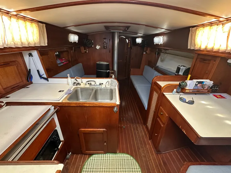 Slide: The Image of Interior of a 1980 Morgan 382 sailboat with wood finishes and compact kitchen area. - 4