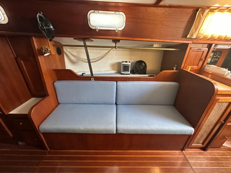Slide: The Image of 1980 Morgan 382 yacht interior with blue cushioned seating and wooden cabinetry. - 5