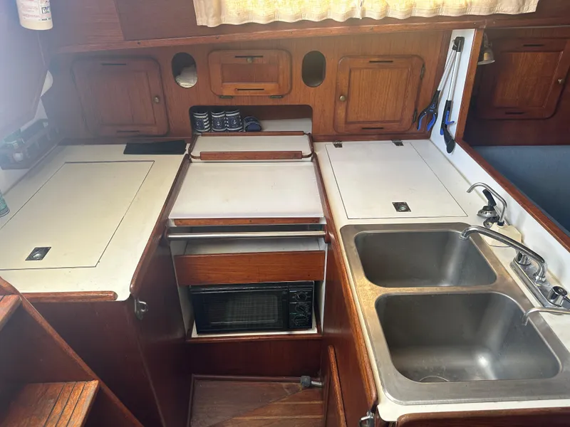 Slide: The Image of 1980 Morgan 382 yacht kitchen with wooden cabinets, dual sinks, and compact appliances. - 9