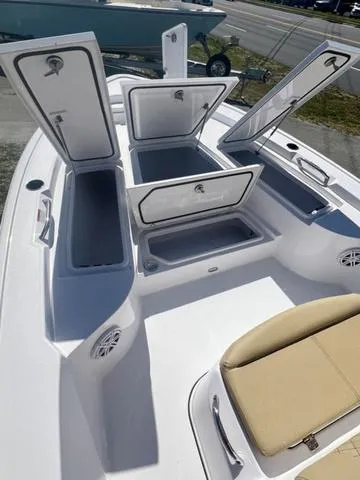 Slide: The Image of 2025 Sportsman Masters 247 boat with open storage compartments and beige seating. - 12