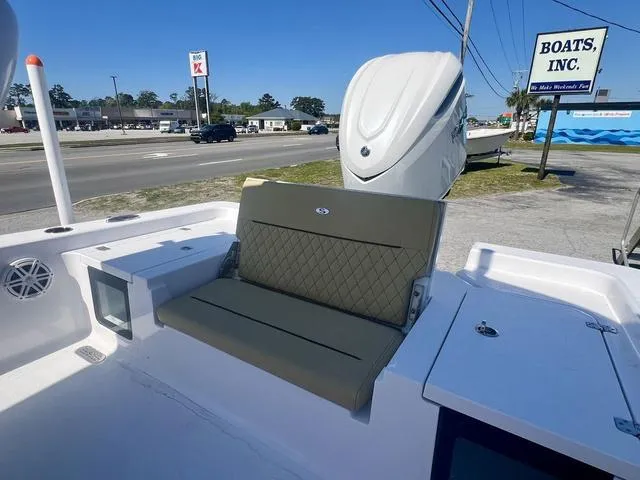 Slide: The Image of 2025 Sportsman Masters 247 boat with seating, parked near Boats Inc. dealership. - 17