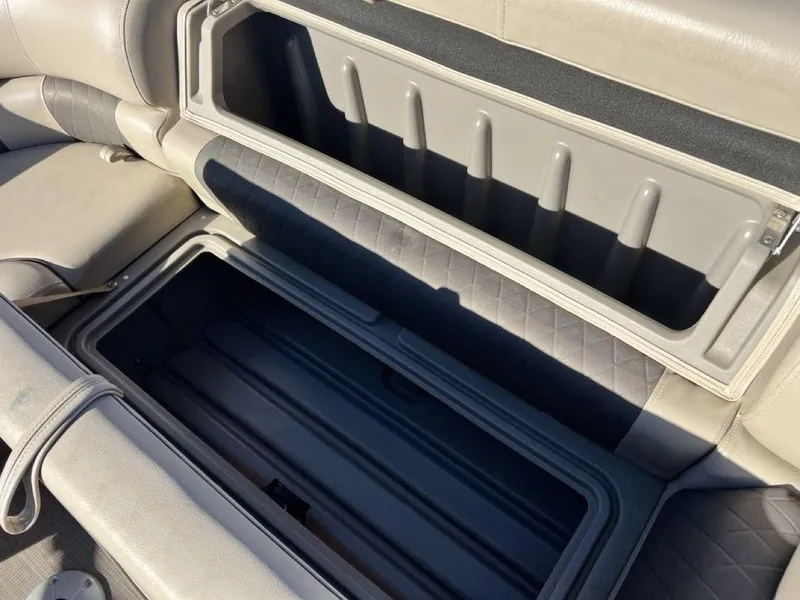 Slide: The Image of 2021 Sun Tracker PARTY BARGE® 20 DLX storage compartment with open lid, showcasing interior space. - 20