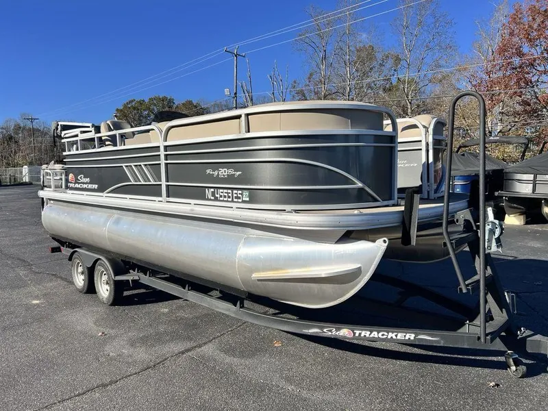 Slide: The Image of 2021 Sun Tracker PARTY BARGE® 20 DLX pontoon boat on trailer, parked outdoors. - 3