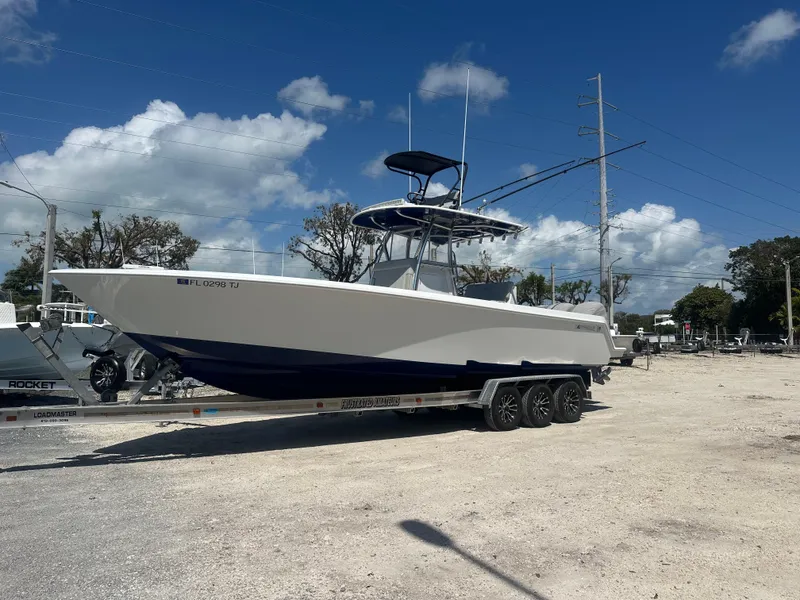 Slide: The Image of 2023 Contender 32 ST boat on trailer under clear blue sky. - 1