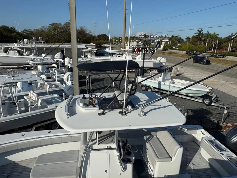 Slide: The Image of 2023 Contender 32 ST boat in a marina, surrounded by other vessels. - 19