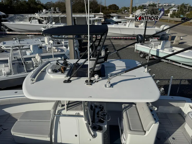 Slide: The Image of 2023 Contender 32 ST boat with T-top and fishing rods, docked in a marina. - 23