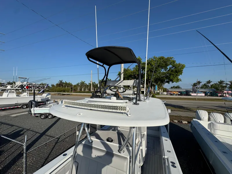 Slide: The Image of 2023 Contender 32 ST boat with elevated helm, parked outdoors under clear sky. - 25