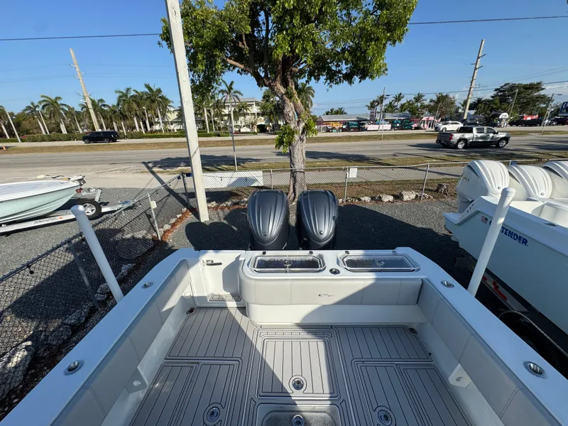 Slide: The Image of 2023 Contender 32 ST boat with dual outboard motors, parked near a road. - 30