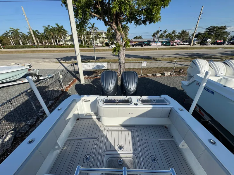 Slide: The Image of 2023 Contender 32 ST boat with dual engines, docked near a road and palm trees. - 31