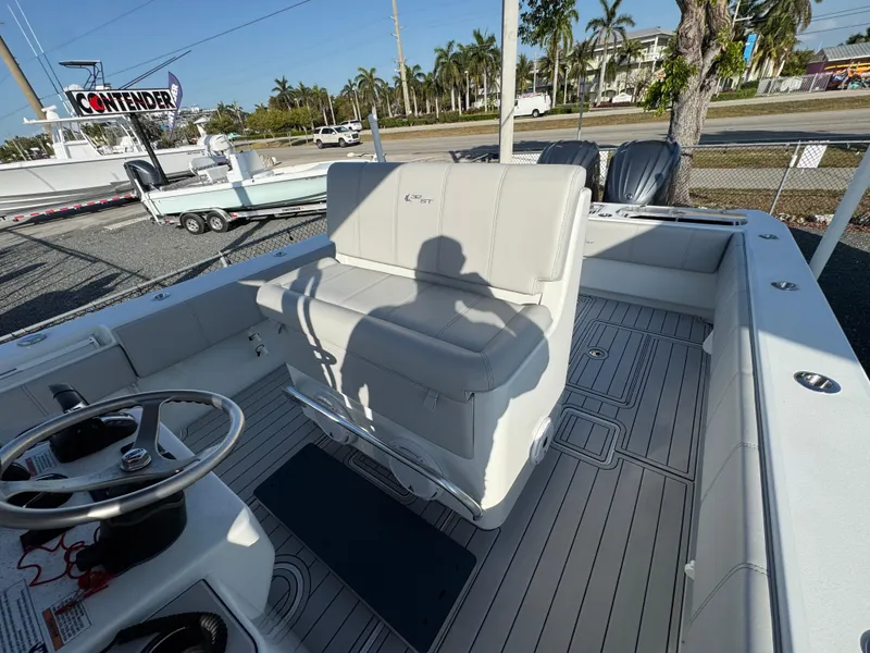 Slide: The Image of 2023 Contender 32 ST boat interior with steering wheel and seating, parked outdoors. - 36