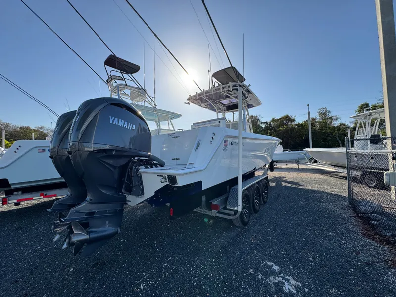 Slide: The Image of 2023 Contender 32 ST boat with dual Yamaha engines, parked on a trailer in a sunny lot. - 49