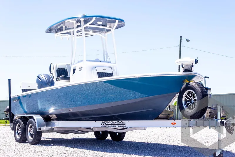 Slide: The Image of 2025 Tidewater 2110 Bay Max boat on trailer, blue hull, outdoor display. - 11