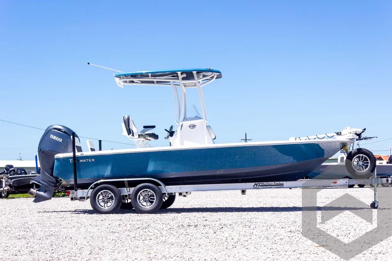 Slide: The Image of 2025 Tidewater 2110 Bay Max boat on trailer, blue hull, clear sky background. - 12