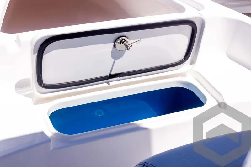 Slide: The Image of 2025 Tidewater 2110 Bay Max boat storage compartment with lock and blue interior. - 27