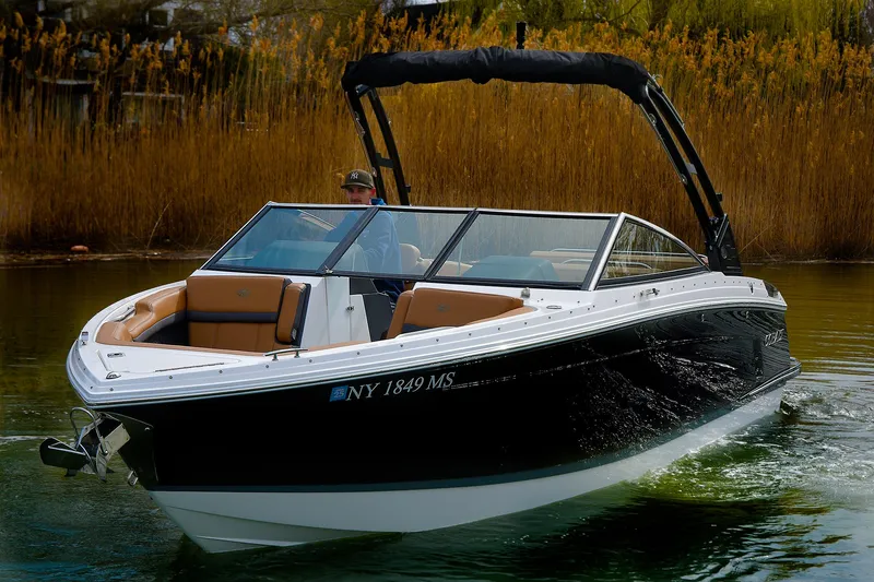 Slide: The Image of 2022 Cobalt R6 boat cruising on a calm lake with reeds in the background. - 0