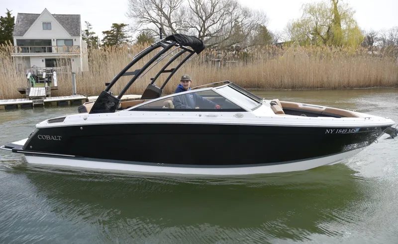 Slide: The Image of 2022 Cobalt R6 boat on calm water near a dock and reeds. - 1