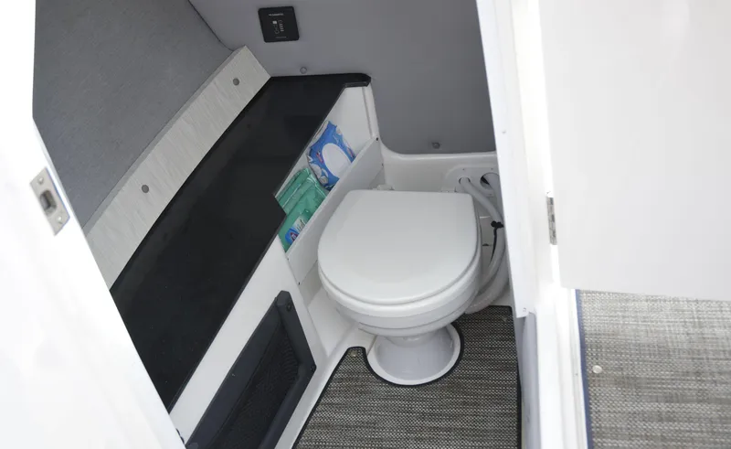 Slide: The Image of 2022 Cobalt R6 boat interior bathroom with toilet and storage shelf. - 22
