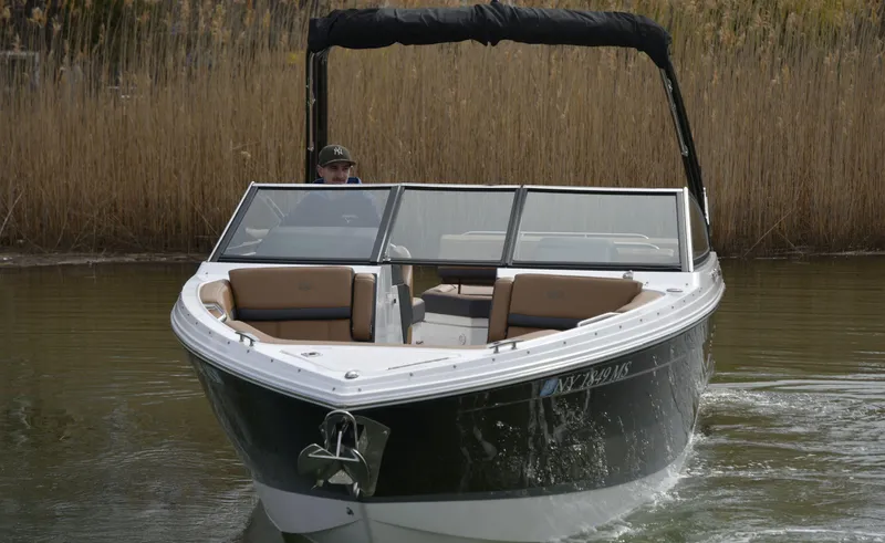 Slide: The Image of 2022 Cobalt R6 boat cruising on a calm waterway with reeds in the background. - 4