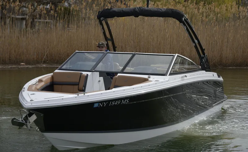 Slide: The Image of 2022 Cobalt R6 boat cruising on a calm waterway with lush reeds in the background. - 5