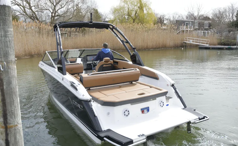 Slide: The Image of 2022 Cobalt R6 boat navigating a calm waterway with reeds and trees in the background. - 8