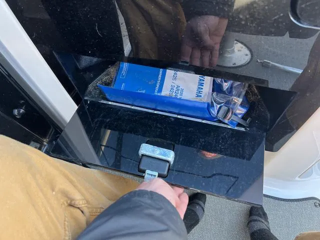 Slide: The Image of 2020 Yamaha Boats AR240 storage compartment with manual and accessories. - 12