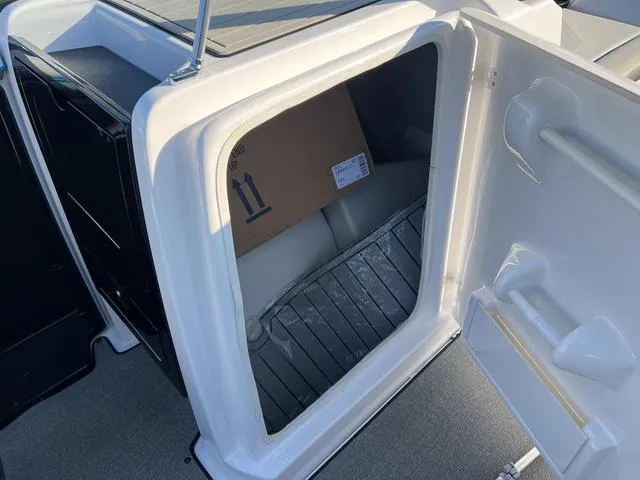Slide: The Image of 2020 Yamaha AR240 boat storage compartment with open hatch, showing interior space. - 18