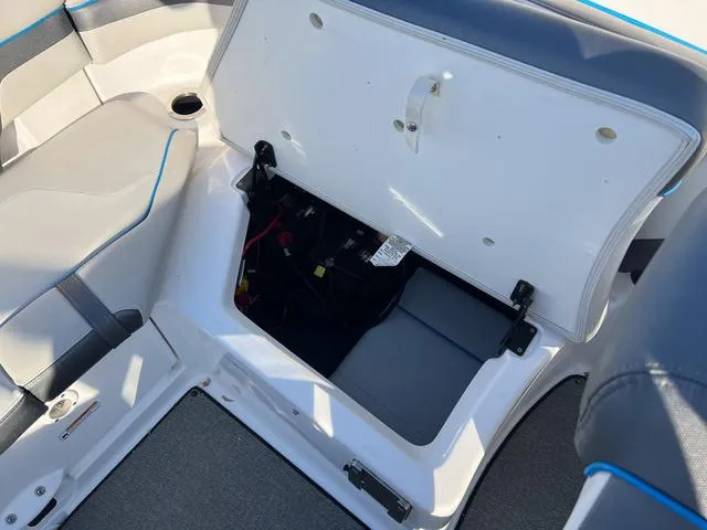 Slide: The Image of 2020 Yamaha AR240 boat storage compartment with open lid, revealing interior space. - 8
