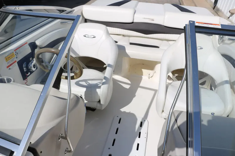 Slide: The Image of 2009 Glastron GT185 boat interior with white seating and steering wheel. - 19