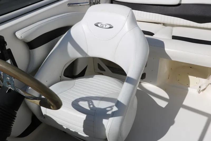 Slide: The Image of 2009 Glastron GT185 boat interior with white captain's seat and steering wheel. - 20