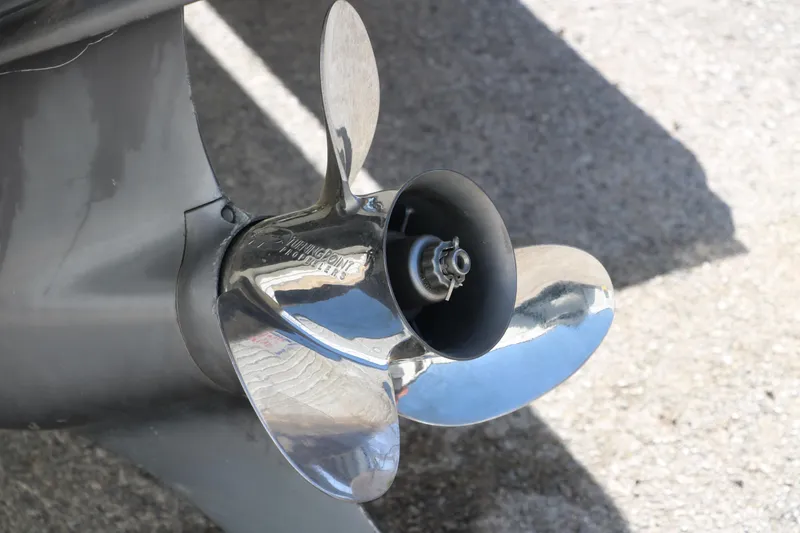 Slide: The Image of 2009 Glastron GT185 boat propeller, shiny metal blades on concrete surface. - 31