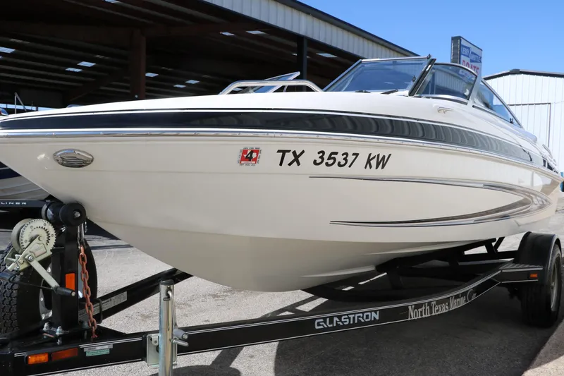 Slide: The Image of 2009 Glastron GT185 boat on trailer, displayed outdoors, registration TX 3537 KW. - 7
