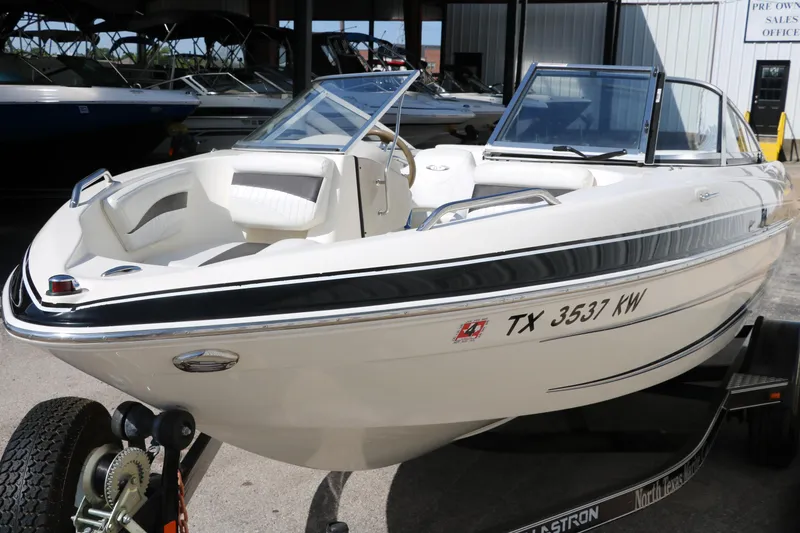 Slide: The Image of 2009 Glastron GT185 boat on trailer, white exterior, parked in marina. - 8