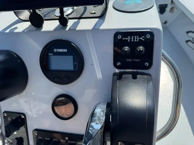 Slide: The Image of Control panel of a 2023 Hell's Bay Professional boat with Yamaha display and trim tabs. - 12