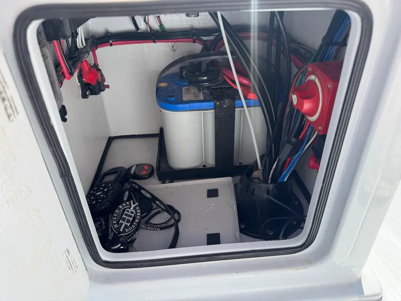 Slide: The Image of 2023 Hell's Bay Professional boat battery compartment with wiring and equipment. - 13