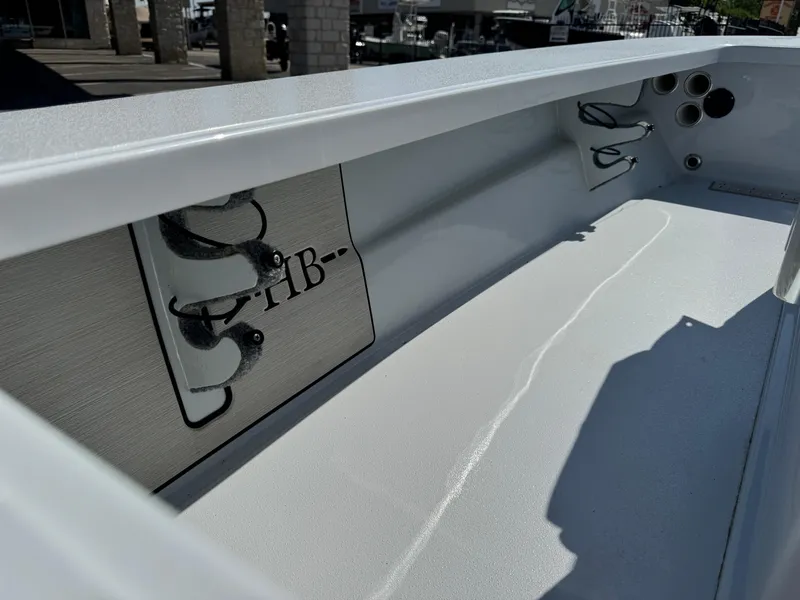 Slide: The Image of 2023 Hell's Bay Professional boat interior with rod holders and storage compartments. - 27