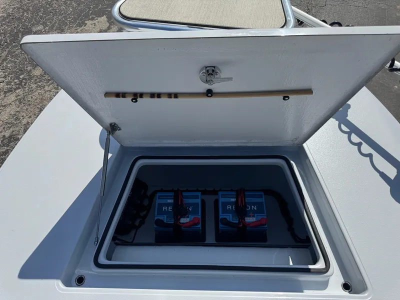 Slide: The Image of 2023 Hell's Bay Professional boat battery compartment with dual batteries and secure storage. - 31