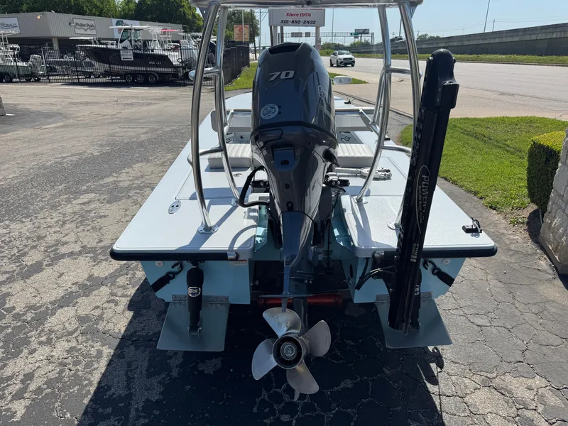 Slide: The Image of 2023 Hell's Bay Professional boat with 70 HP outboard motor, parked on pavement. - 4