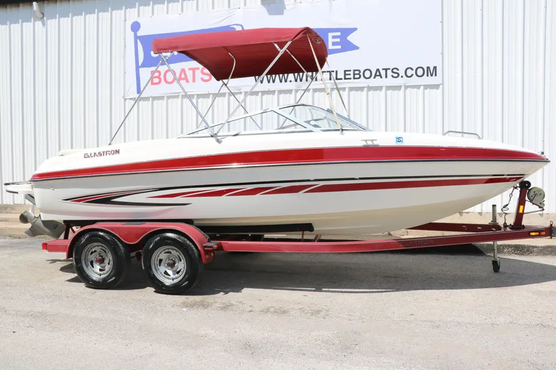 Slide: The Image of 2007 Glastron GT205 boat with red accents and canopy on a trailer. - 1