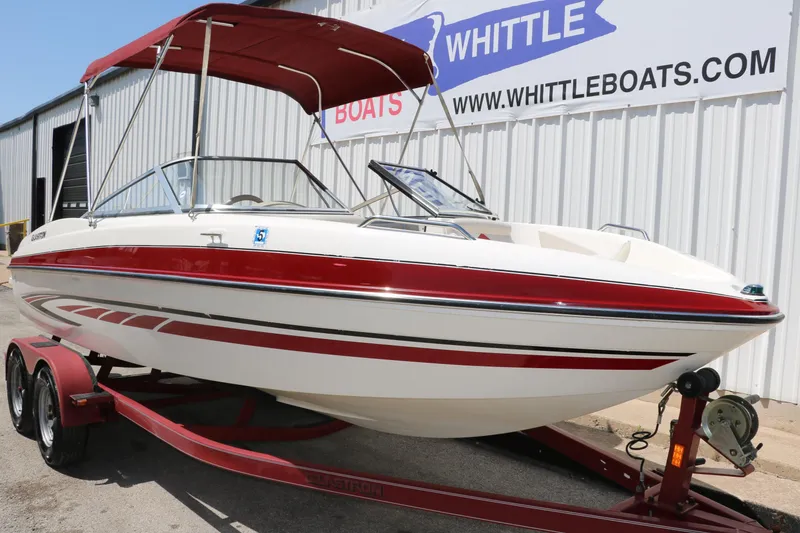 Slide: The Image of 2007 Glastron GT205 boat with red accents on a trailer, displayed at Whittle Boats. - 10
