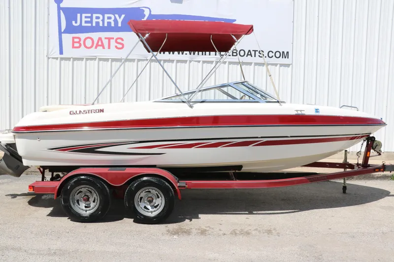 Slide: The Image of 2007 Glastron GT205 boat with red accents on a trailer, displayed outdoors. - 12