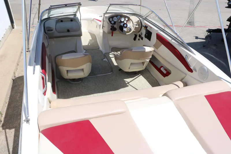 Slide: The Image of 2007 Glastron GT205 boat interior with beige and red seating, steering console, and open cockpit. - 13