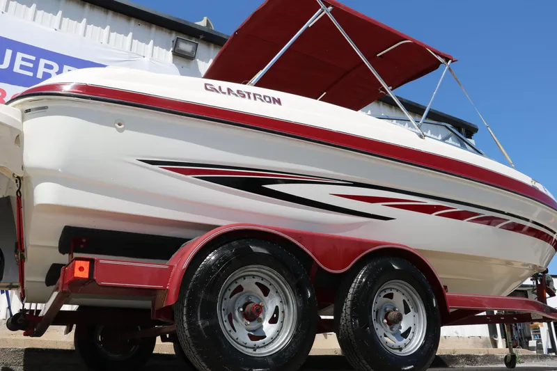 Slide: The Image of 2007 Glastron GT205 boat on trailer with red accents and canopy. - 2
