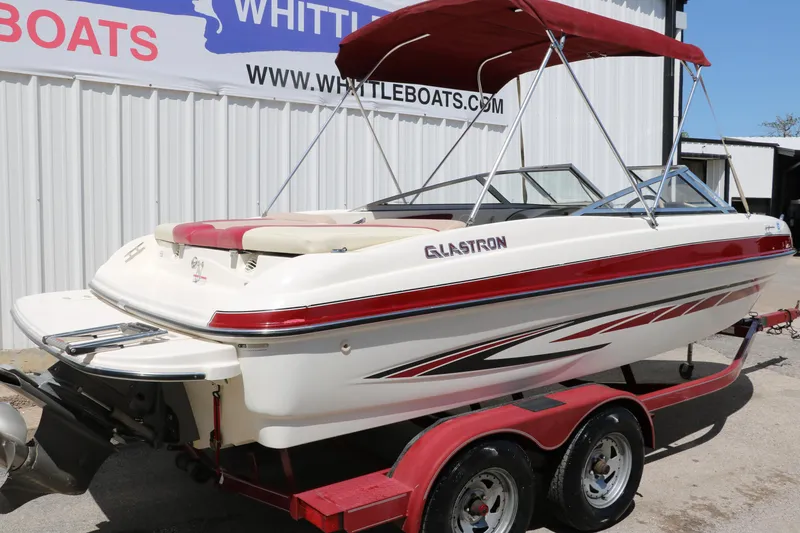 Slide: The Image of 2007 Glastron GT205 boat with red accents on a trailer, parked outside Whittle Boats. - 3