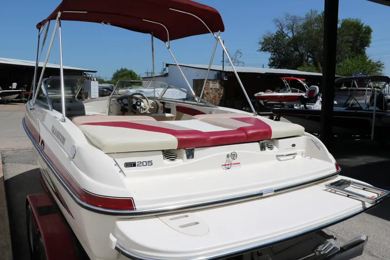 Slide: The Image of 2007 Glastron GT205 boat with red canopy, parked outdoors. - 5