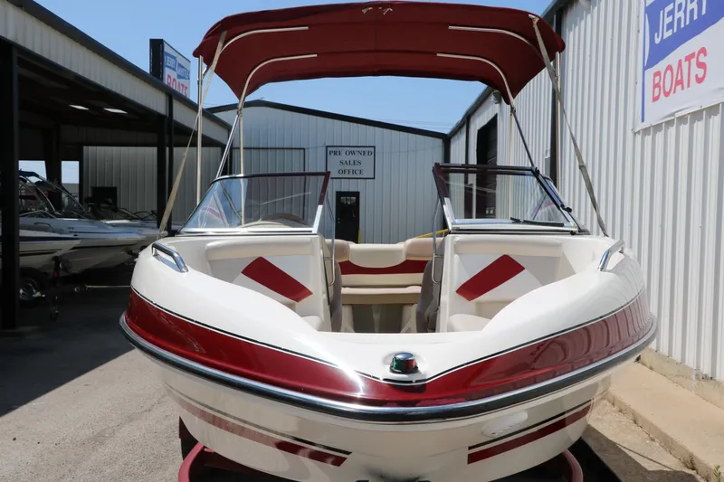 Slide: The Image of 2007 Glastron GT205 boat with red accents and canopy, displayed at a dealership. - 9