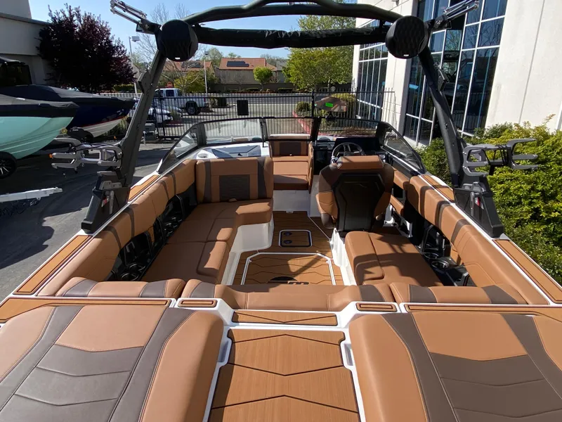 Slide: The Image of 2025 Malibu Wakesetter 22 MXZ interior with tan and gray seating, showcasing luxury and style. - 8